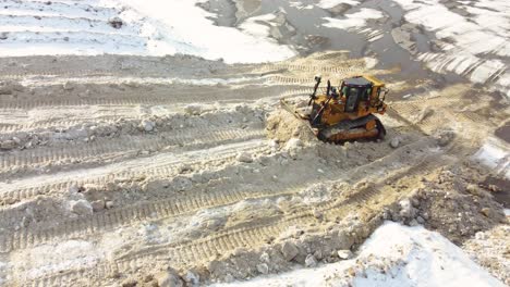 Bulldozer-Shoving-Snow-At-Snow-Dump-In-Montreal,-Canada