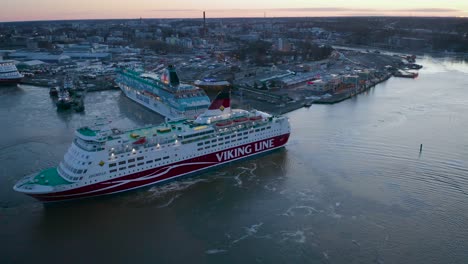 Luftaufnahme-Des-Kreuzfahrtschiffs-Amorella-Der-Viking-Line,-Das-Sich-Bei-Der-Ankunft-Im-Hafen-Bei-Schwachem-Morgensonnenaufgang-Rückwärts-Bewegt