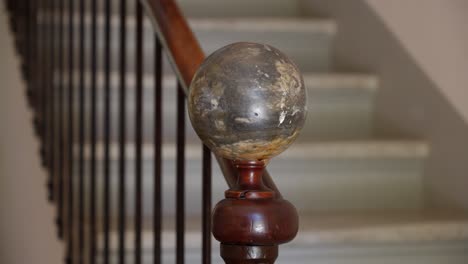 Slow-orbiting-shot-of-a-marble-ball-handrail-on-a-staircase-within-a-villa