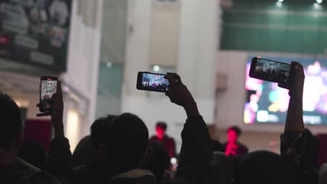 People-crowd-filming-musical-group-performances-on-phones-at-music-concert