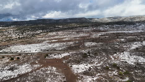 Aerial-View-Of-Vehicles-Driving-On-Remote-Road-In-Barren-Landscape-Near-Utah,-United-States