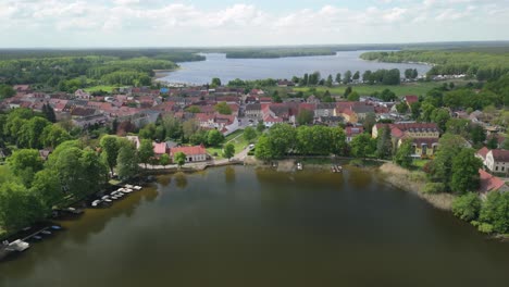 Una-Pintoresca-Vista-Aérea-De-Una-Encantadora-Ciudad-Situada-A-Orillas-De-Un-Tranquilo-Lago