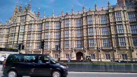 Toma-Panorámica-De-Las-Casas-Del-Parlamento,-Vista-Desde-Abingdon-Street-En-Westminster,-Londres,-Inglaterra.