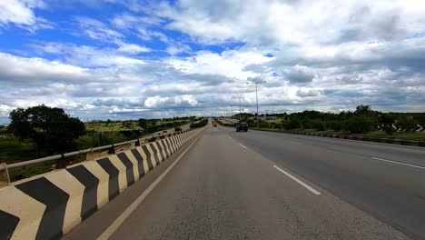 Motorradfahren-Auf-Asphaltierter-Straße-Mit-Herrlich-Blauem-Himmel-Und-Wolkenflecken