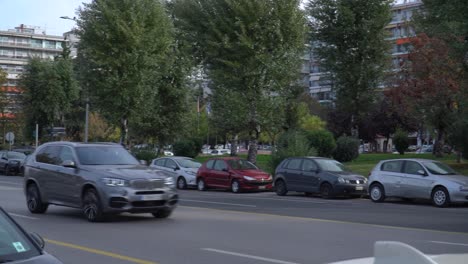 Personas-Que-Viajan-En-Sus-Automóviles-En-Una-Ciudad,-Panorámica-Lenta