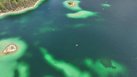 Antena-De-Las-Vibrantes-Aguas-Turquesas-Del-Eibsee-Y-Pequeñas-Islas-Boscosas-Rodeadas-De-Exuberantes-Costas-Verdes-En-Grainau,-Alemania