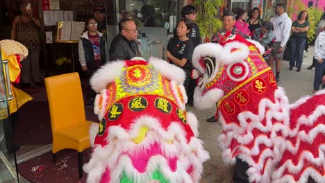 Par-De-Artistas-De-Dragones-De-Colores-Brillantes-Disfrazados-Bailando-En-La-Calle-De-Los-Ángeles-Fuera-De-Negocios-Durante-El-Desfile-De-Chinatown