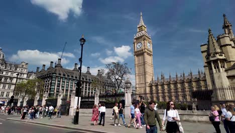 Daytime-view-of-pedestrians-walking-in-front-of-the-Palace-of-Westminster-in-London,-England,-featuring-the-British-Houses-of-Parliament,-Big-Ben