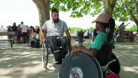 Slow-motion-shot-of-a-disabled-man-teaching-kids-how-to-use-a-wheelchair