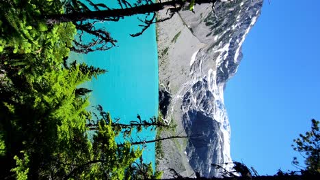 The-Iconic-Turquoise-Waters-in-Joffre-Lakes---Slow-Walking-Reveal-through-the-Trees-as-the-Hiking-Trail-nears-the-Icy-Cold-Glacial-Meltwater