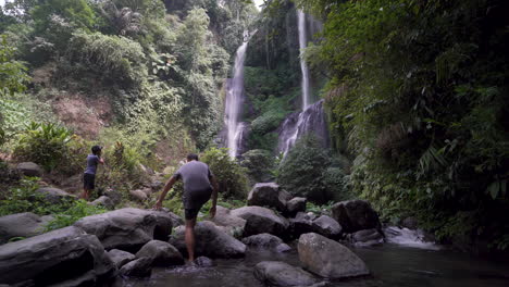 Eine-Person,-Die-An-Einem-Sonnigen-Tag-Im-Wasser-Auf-Einen-Wunderschönen-Wasserfall-In-Bali,-Indonesien-Zuläuft