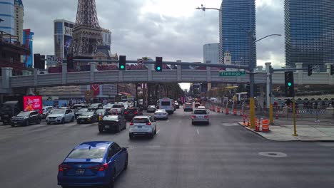 Driving-on-Las-Vegas-Strip-Point-of-View,-Cars-and-Hotel-Casinos-Under-Cloudy-Sky