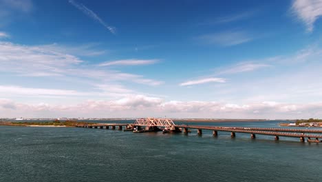 Eine-Luftaufnahme-Der-South-Channel-Subway-Bridge-In-Der-Jamaica-Bay-An-Einem-Sonnigen-Tag-Mit-Blauem-Himmel-Und-Weißen-Wolken