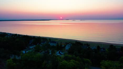 Vista-Aérea-Por-Drones-Del-Amanecer-Sobre-Casas-De-Playa-Con-Coloridos-Reflejos-De-Las-Olas-Del-Océano-Y-Casas-De-Vacaciones-A-Lo-Largo-De-La-Costa-Atlántica-De-Nueva-Inglaterra