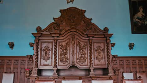 Exquisites,-Aus-Holz-Geschnitztes-Buffet-Mit-Dekorativen-Details-Vor-Einer-Kontrastierenden-Blauen-Wand-Im-Schloss-Trakošćan,-Kroatien