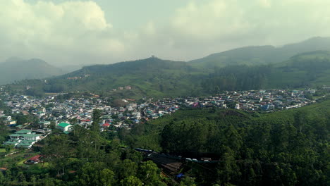 Luftaufnahme-Von-Kleinen-Ortschaften-Inmitten-Von-Teeplantagen-Und-Wäldern-Am-Hang-Der-Stadt-Munnar-In-Kerala,-Indien