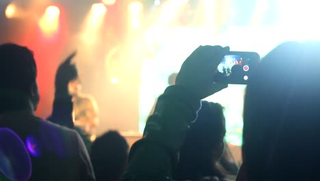 Primer-Plano-Que-Muestra-La-Silueta-De-Gente-De-Fiesta-Celebrando-En-El-Club-Nocturno-Frente-Al-Escenario.