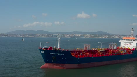 Aerial-orbiting-over-Cargo-ship-moored-on-Atlantic-Ocean,-Portuguese-coastline