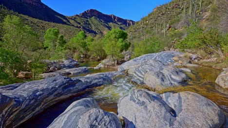 Static-morning-view-of-Sabino-Creek-golden-waters-flowing-through-rocky-terrain-in-Sabino-Canyon