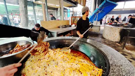 Local-Uzbek-in-Samarkand,-Uzbekistan-are-preparing-and-cooking-Uzbek-pilav-or-plov,-a-national-dish-of-Uzbekistan-and-a-rice-dish-common-for-people-of-Central-Asia