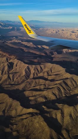 Vertical-Video,-Spirit-Airlines-Airplane-Wing-Above-Desert-Landscape-of-Nevada-USA