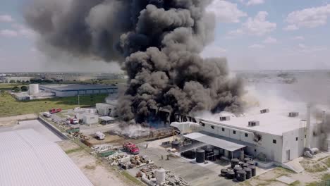 Aerial---textile-factory-fire-in-Reynosa,-Tamaulipas,-Mexico,-wide-shot-approach