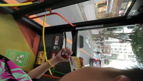 Pokemon-Go-Plus-Player-Riding-A-Bus-In-Tokyo,-Japan