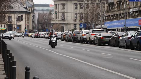 White-Mercedes-van-driving-through-bustling-city-street-in-Bucharest-during-the-day,-urban-traffic-scene
