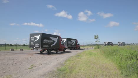 Las-Furgonetas-De-Reparto-De-Hsm-Global-Salen-De-Un-Aparcamiento-En-Una-Zona-Rural-Y-Siguen-El-Rastro