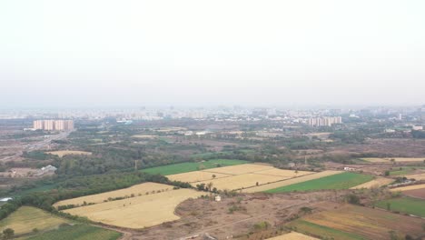 Drone-camera-showing-lots-of-big-fields-and-buildings