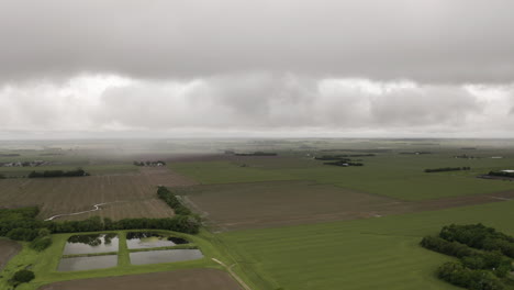 Aerial-drone-moves-through-clouds-above-grassland-and-farmland-in-midwest-of-United-States