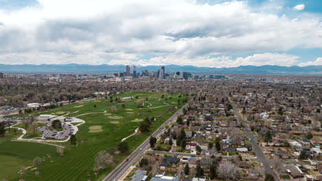 Hiperlapso-Aéreo-De-Camiones-Sobre-El-Parque-De-La-Ciudad-De-Denver-Con-Vista-Al-Horizonte-En-La-Parte-Posterior