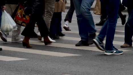 People-crossing-the-street,-blurred-motion,-focus-on-walking-feet,-urban-setting,-daytime,-Bucharest,-Romania