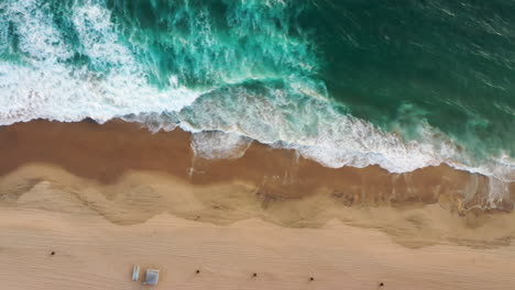 Vista-Aérea-De-Espumosas-Olas-Blancas-Rompiendo-En-La-Orilla-Arenosa-De-La-Playa