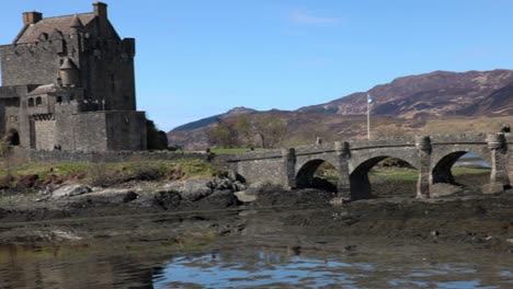 Langsame-Schwenkaufnahme-Von-Touristen,-Die-über-Die-Brücke-Zum-Eilean-Donan-Castle-Gehen