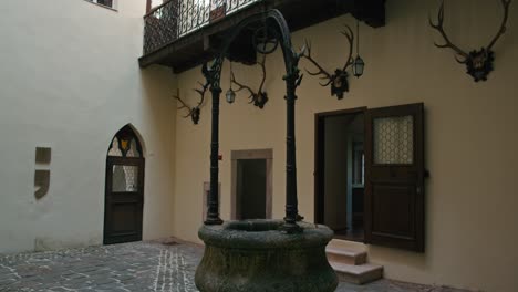 Trakoscan-Castle-courtyard-with-an-ornate-well-and-mounted-antlers-on-the-walls