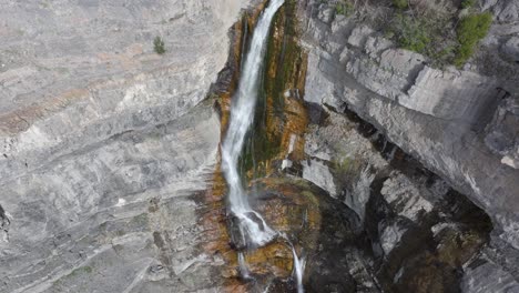 Aerial-track-back-of-mountainside-Bridal-Veil-Falls-in-American-Fork-Canyon,-Utah-during-spring