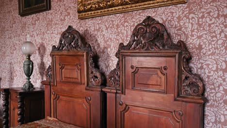 Ornate-wooden-twin-beds-with-intricate-headboards-in-Trakoscan-Castle's-Count-Bedroom,-Croatia