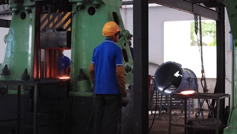 Men-are-carrying-a-partially-cooled-employee-inside-a-lava-bolus-machine,-Industrial-safety-first-concept