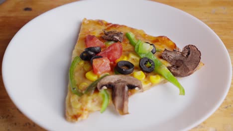 Zoom-at-Vegetarian-pizza-with-olives,-mushrooms,-green-paprika,-tomato,-and-corn