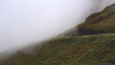 Tres-Ciclistas-De-Montaña-Recorren-Un-Sendero-De-Montaña,-Yendo-A-Velocidad-Media,-Desapareciendo-En-La-Niebla