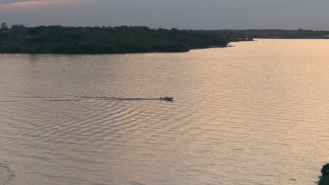 Aerial-Tracking-Shot-Of-Motorboat-Cruising-In-The-Calm-Waters-Of-Paraná-River,-In-Posadas,-Misiones,-Argentina