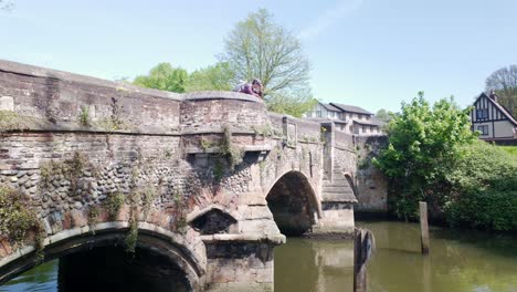 Una-Mujer-Se-Paró-En-El-Puente-Arqueado-Medieval-De-Los-Obispos-Mirando-Por-Encima-Del-Parapeto-Hacia-El-Río-Wensum