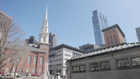 Looking-up-at-a-old-church-steeple-and-other-high-rises-in-the-Boston-Common-public-park-in-downtown-Boston,-Massachusetts-in-4K