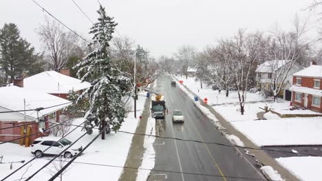 Workers-fixing-aftermath-of-snow-storm-in-Canada-suburbs,-aerial-drone-view