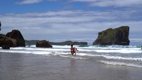 Woman-And-Kids-Playing-In-Invigorating-Waves-Of-Asturias-Coast,-Spain