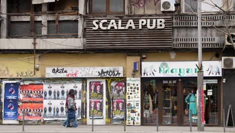 Street-view-of-Scala-Pub-in-Bucharest-showcasing-urban-graffiti-and-advertisements