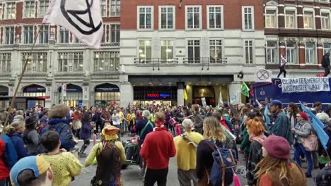 Extinction-Rebellion-Demonstranten-Tanzen,-Um-Das-Bewusstsein-Vor-Der-Tesco-U-Bahn-In-Der-Liverpool-Street-Station-Zu-Schärfen