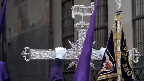 Ein-Büßer-Mit-Einem-Massiven-Capirote-Hält-Ein-Riesiges-Silbernes-Kreuz-Während-Der-Osterfeierlichkeiten-In-Madrid