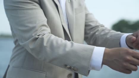 Groom-adjusting-suit-jacket-sleeves-on-wedding-day